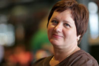 The happy mature woman poses in a cafe